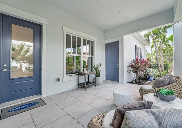 a living room with furniture a large window and wooden floor