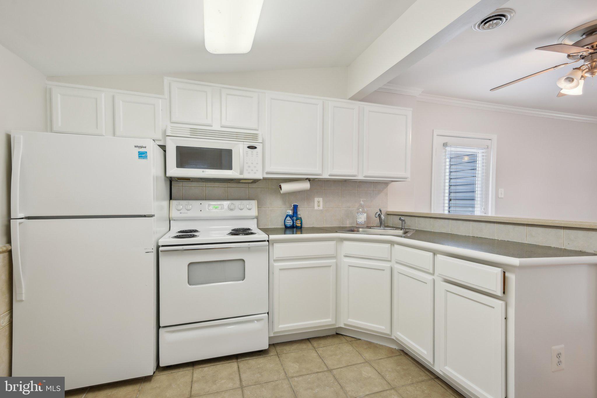 1813 Keymar Road Edgewater, MD 21037 - Photo 13 of 38 a kitchen with white cabinets sink and white appliances