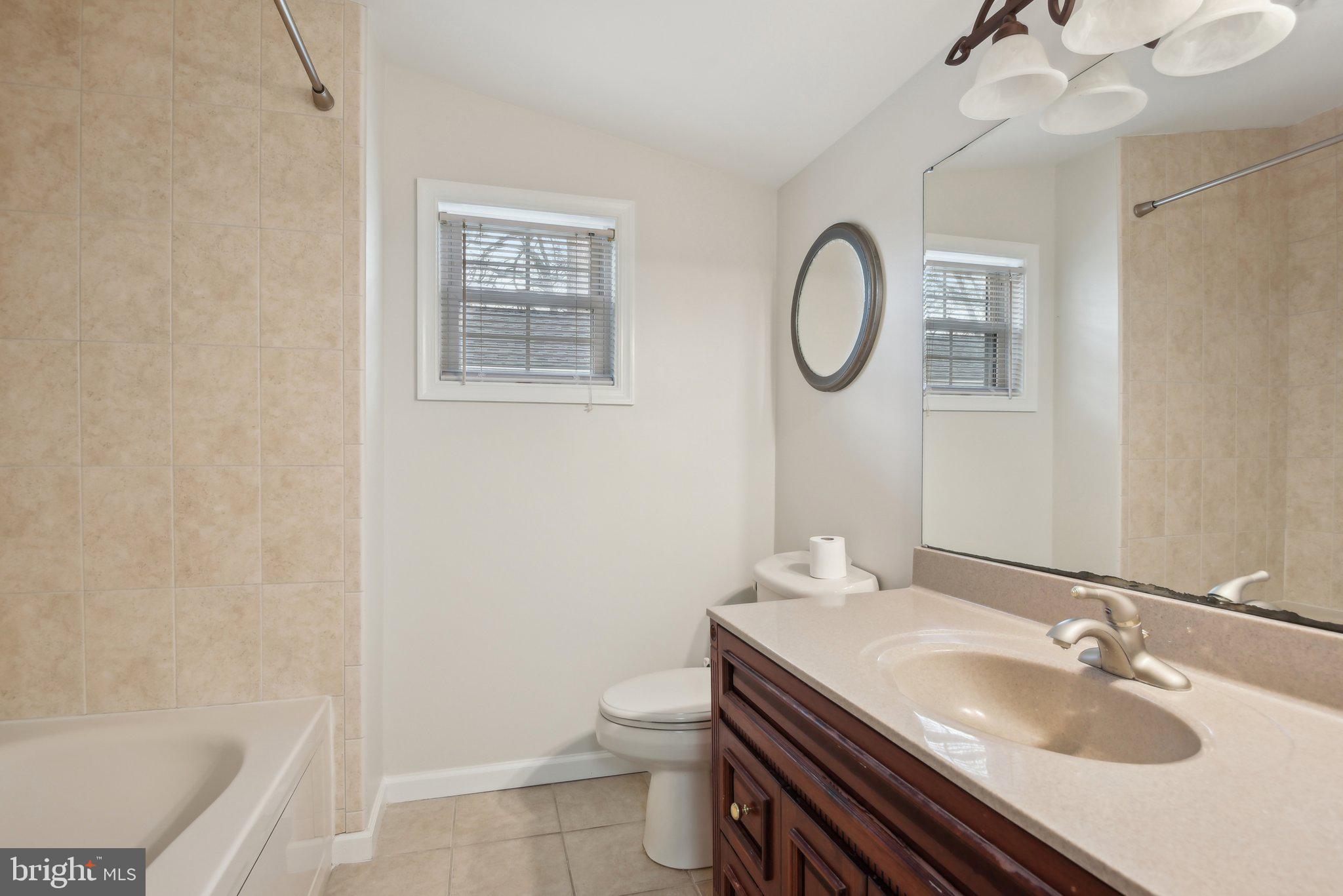 1813 Keymar Road Edgewater, MD 21037 - Photo 20 of 38 a bathroom with a granite countertop toilet a sink and a mirror
