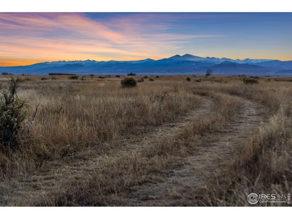 a view of mountain with sunset in background