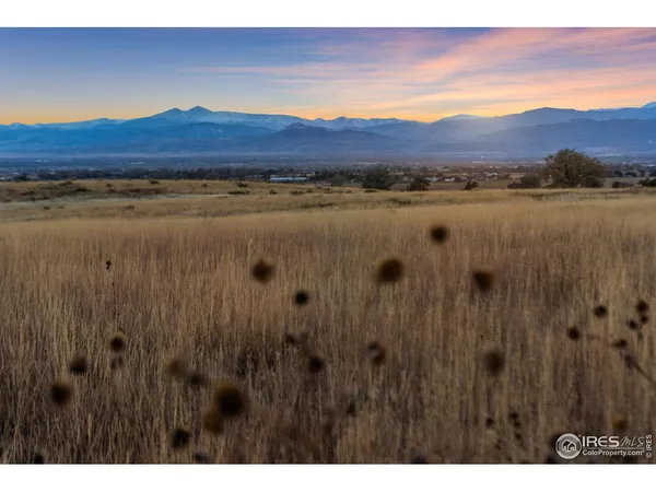 a view of mountain with sunset in background