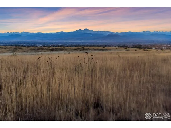 a view of mountain with sunset in background