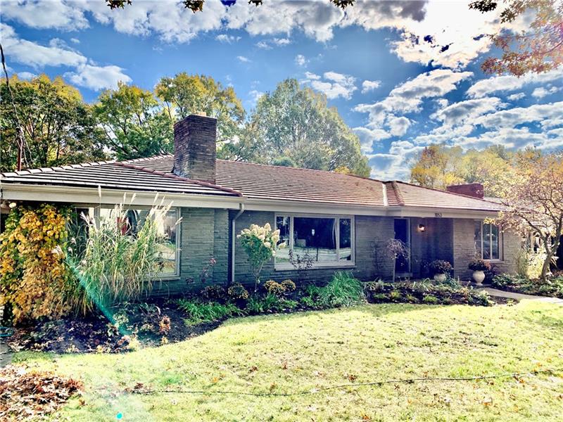 Beautifully landscaped front view of house. Tile roof.