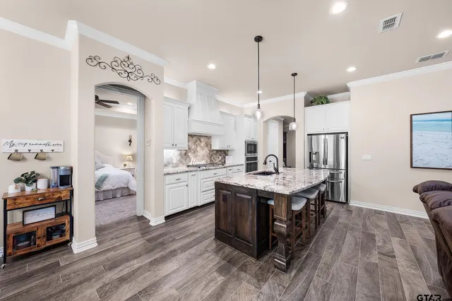 a large kitchen with cabinets wooden floor and stainless steel appliances
