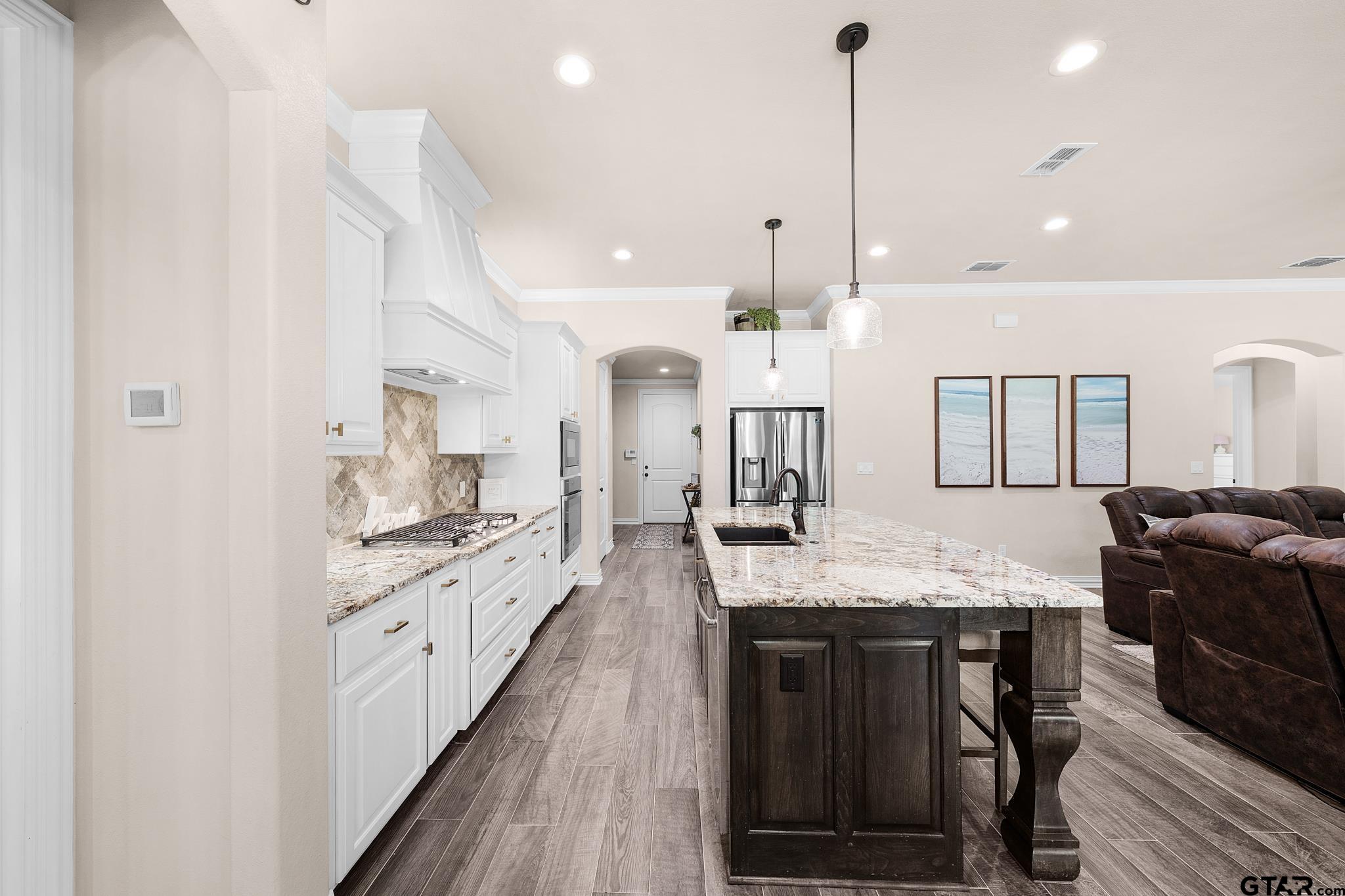 3922 Gable Crest Lane Longview, TX 75605 - Photo 14 of 36 a large kitchen with stainless steel appliances kitchen island granite countertop a stove a sink a dining table and chairs with wooden floor