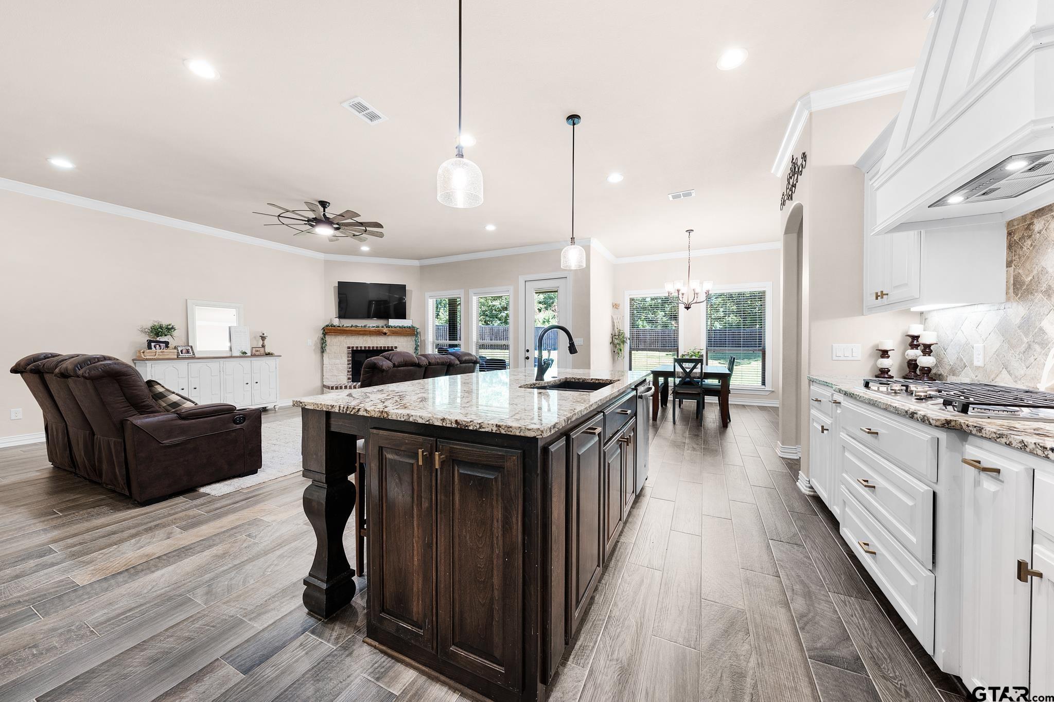 3922 Gable Crest Lane Longview, TX 75605 - Photo 16 of 36 a kitchen with stainless steel appliances granite countertop a stove top oven a refrigerator a sink dishwasher and couches with wooden floor