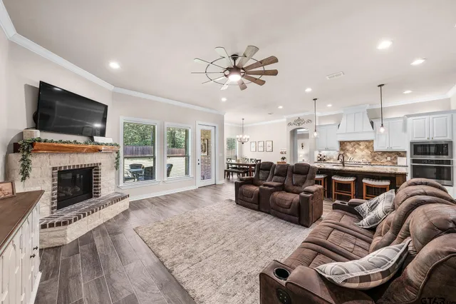 a living room with furniture a flat screen tv and a fireplace