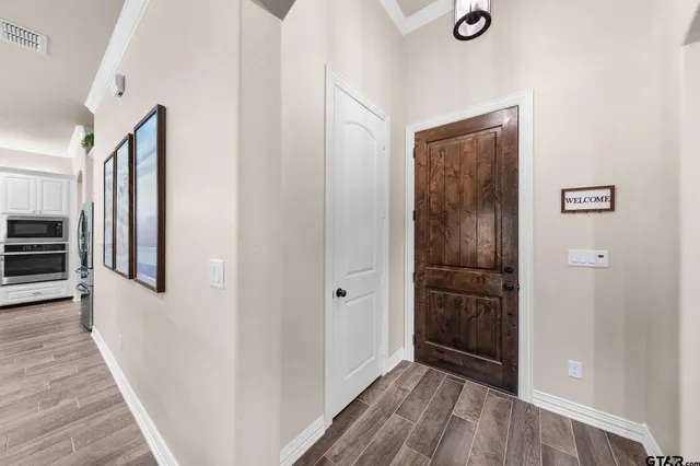 a view of a hallway with wooden floor and staircase