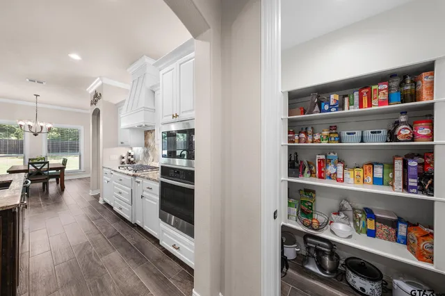 a open kitchen with white cabinets and stainless steel appliances