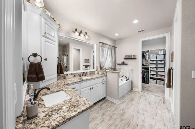 a large white kitchen with a sink and cabinets