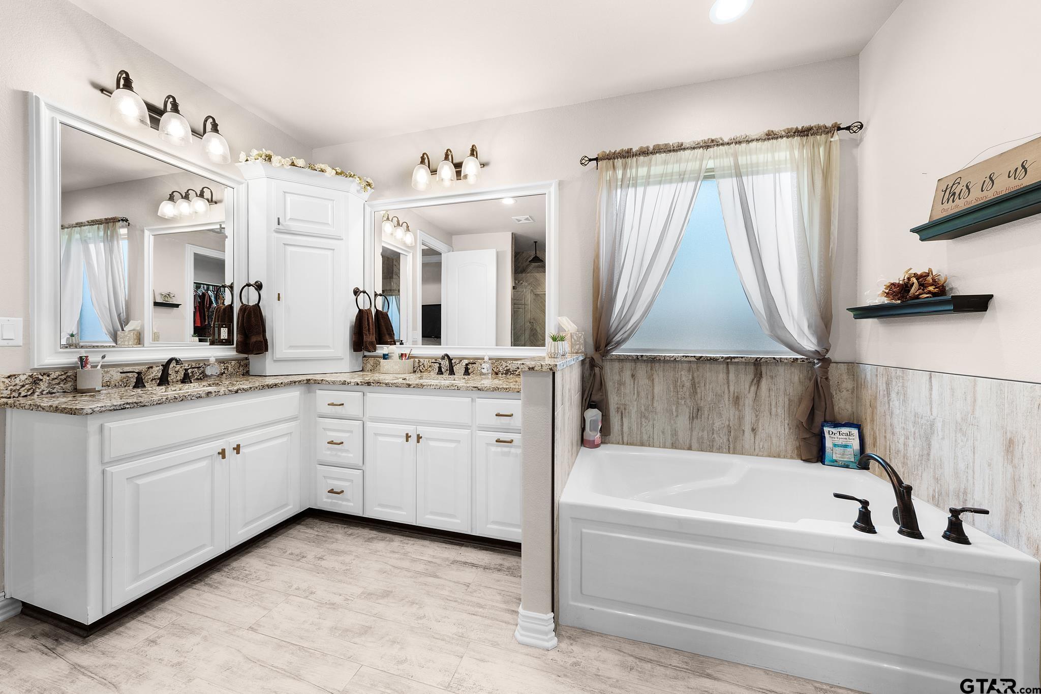 3922 Gable Crest Lane Longview, TX 75605 - Photo 29 of 36 a bathroom with a granite countertop sink mirror and a bathtub