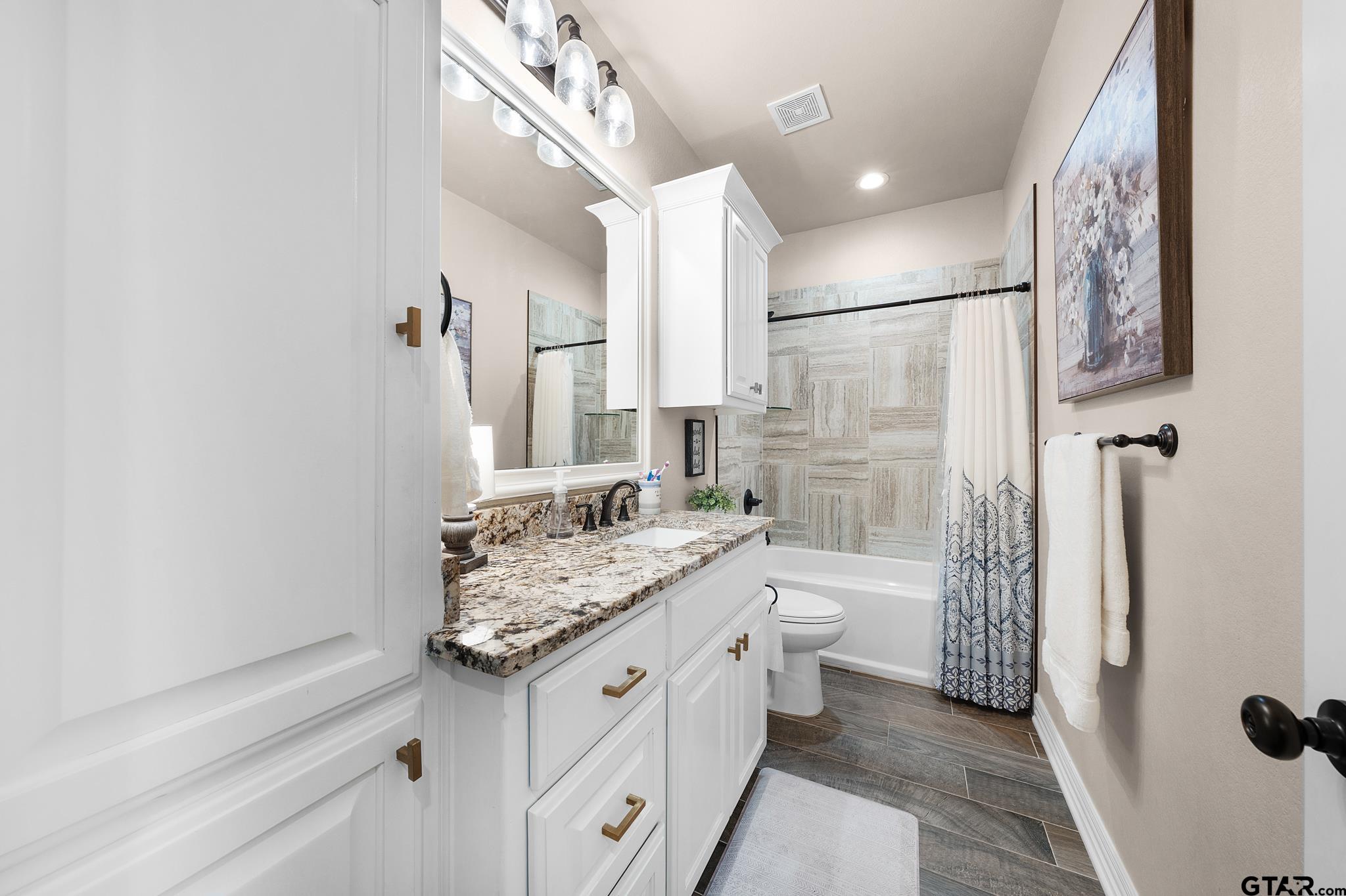 3922 Gable Crest Lane Longview, TX 75605 - Photo 33 of 36 a spacious bathroom with a granite countertop sink a toilet and shower