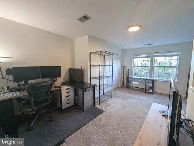 a view of a workspace with furniture and a window