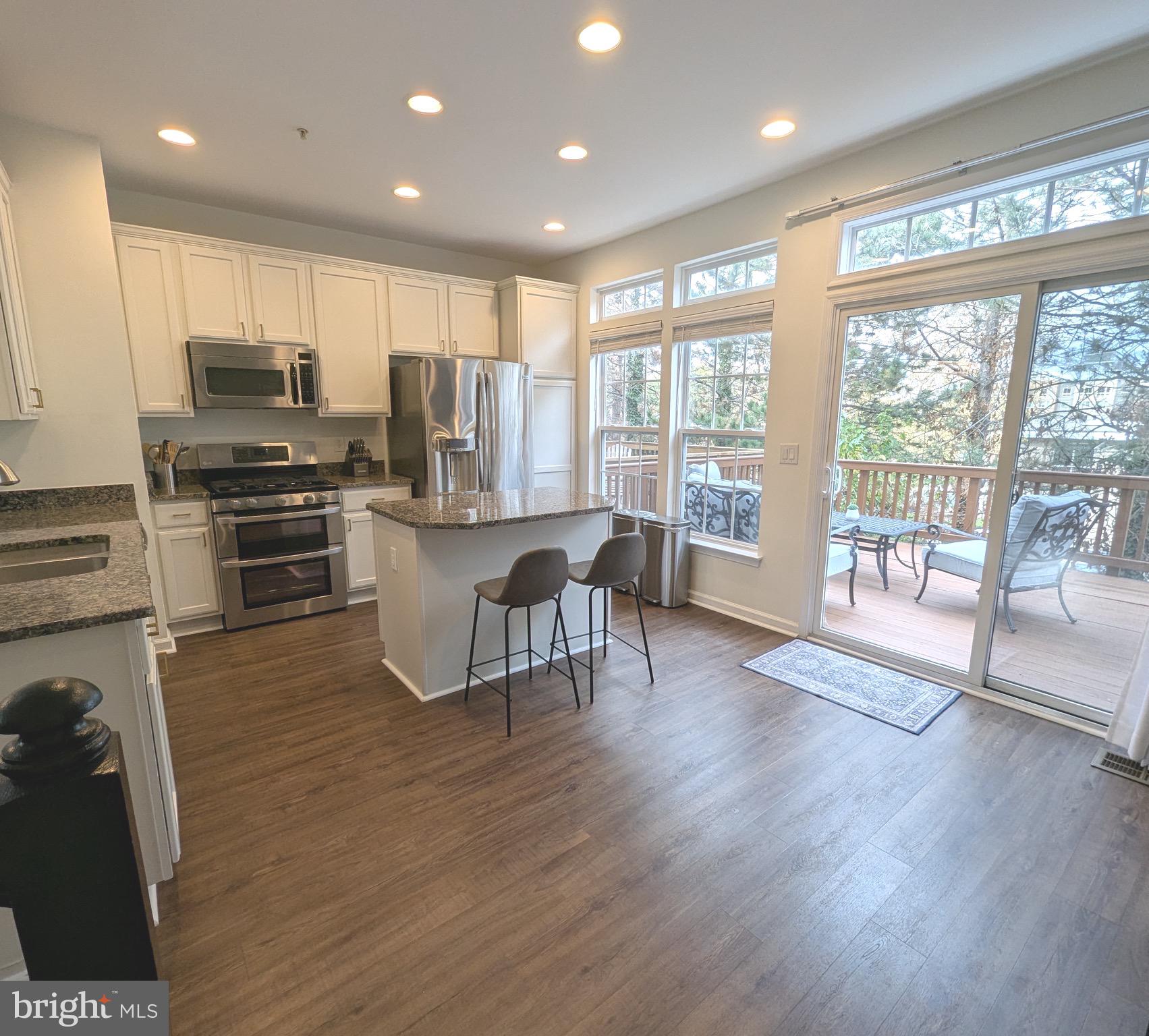 2922 Huntington Grove Square Alexandria, VA 22306 - Photo 7 of 30 a kitchen with stainless steel appliances granite countertop a stove top oven a refrigerator a sink with island and chairs
