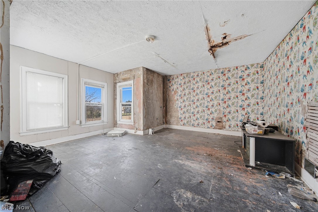 4677 Rock Spring Road Ravenna, OH 44266 - Photo 19 of 35 Empty room with a textured ceiling and wallpapered walls