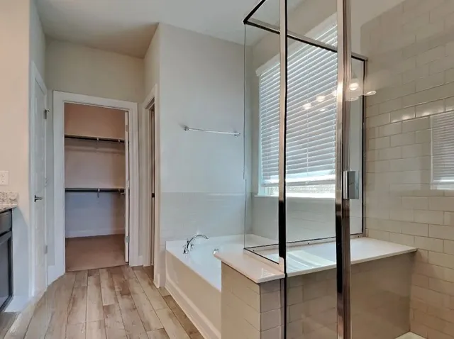 an empty room with chandelier fan and windows