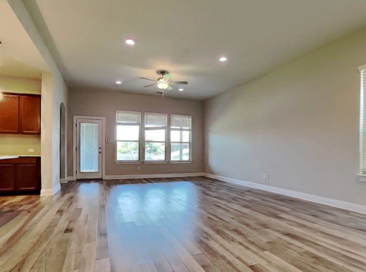3610 Thunian Pass Pflugerville, TX 78660 - Photo 2 of 27 a view of an empty room with a window and wooden floor