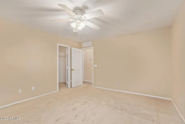 a view of a white house with a big yard and potted plants