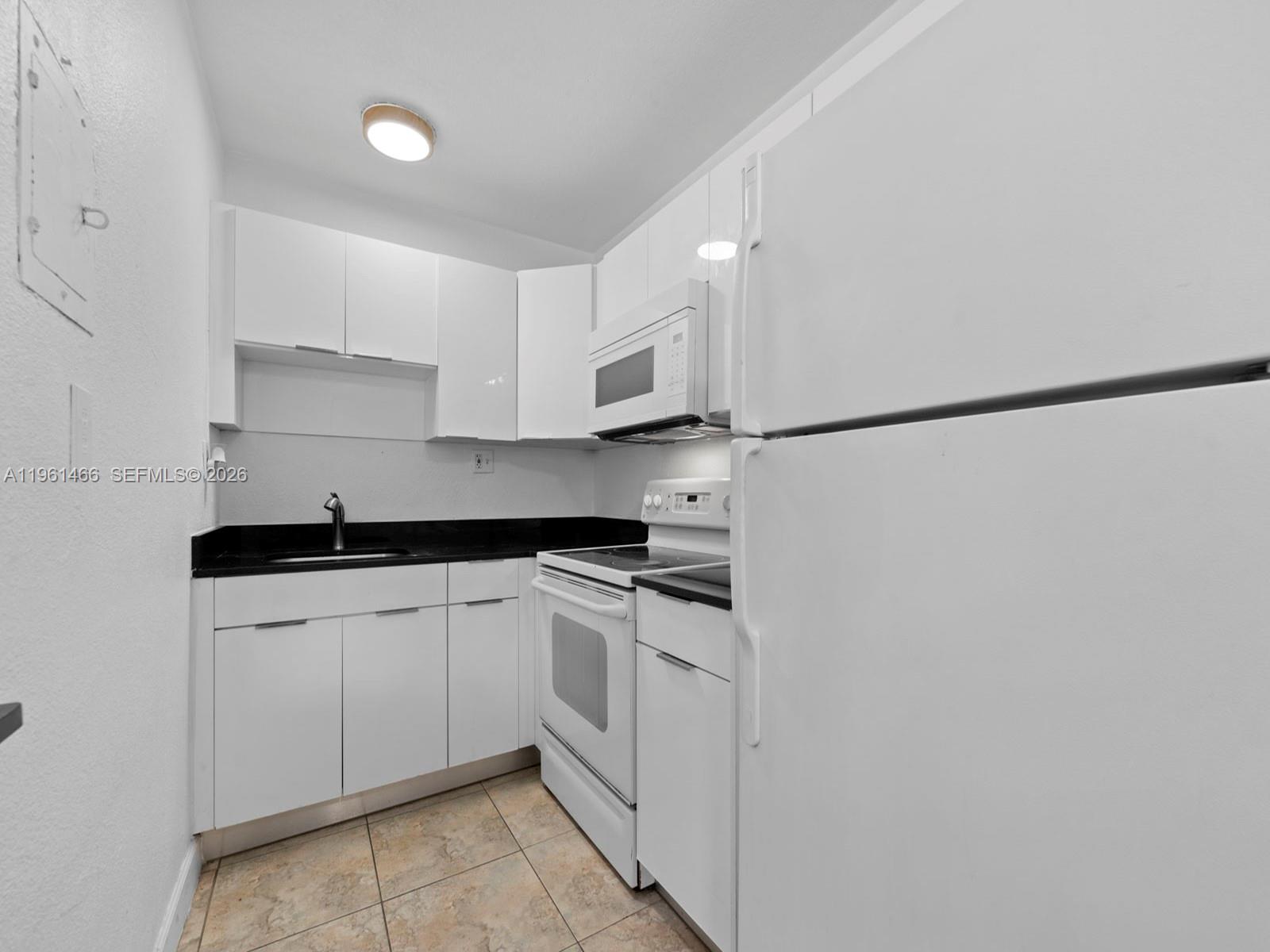4444 Southwest 67th Avenue, Unit 7 Miami, FL 33155 - Photo 7 of 28 a kitchen with stainless steel appliances white cabinets and a refrigerator