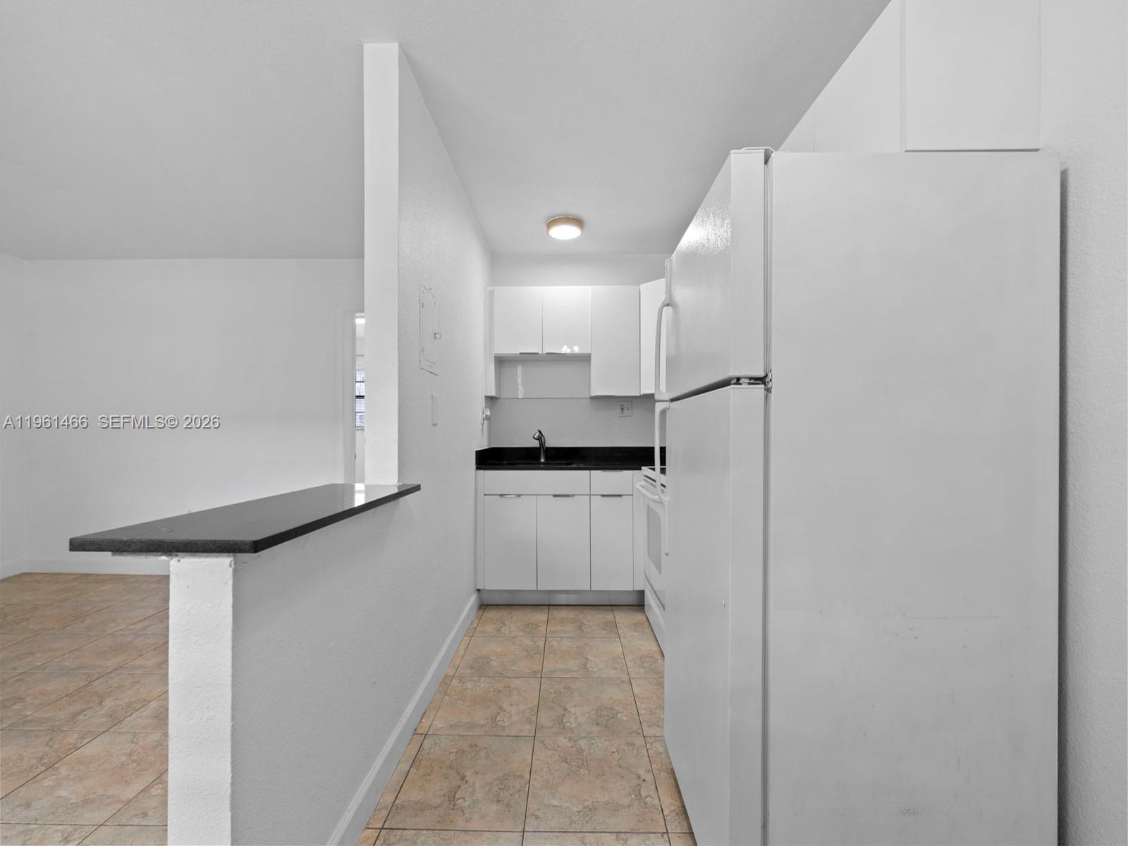 4444 Southwest 67th Avenue, Unit 7 Miami, FL 33155 - Photo 10 of 28 a kitchen with a refrigerator and white cabinets