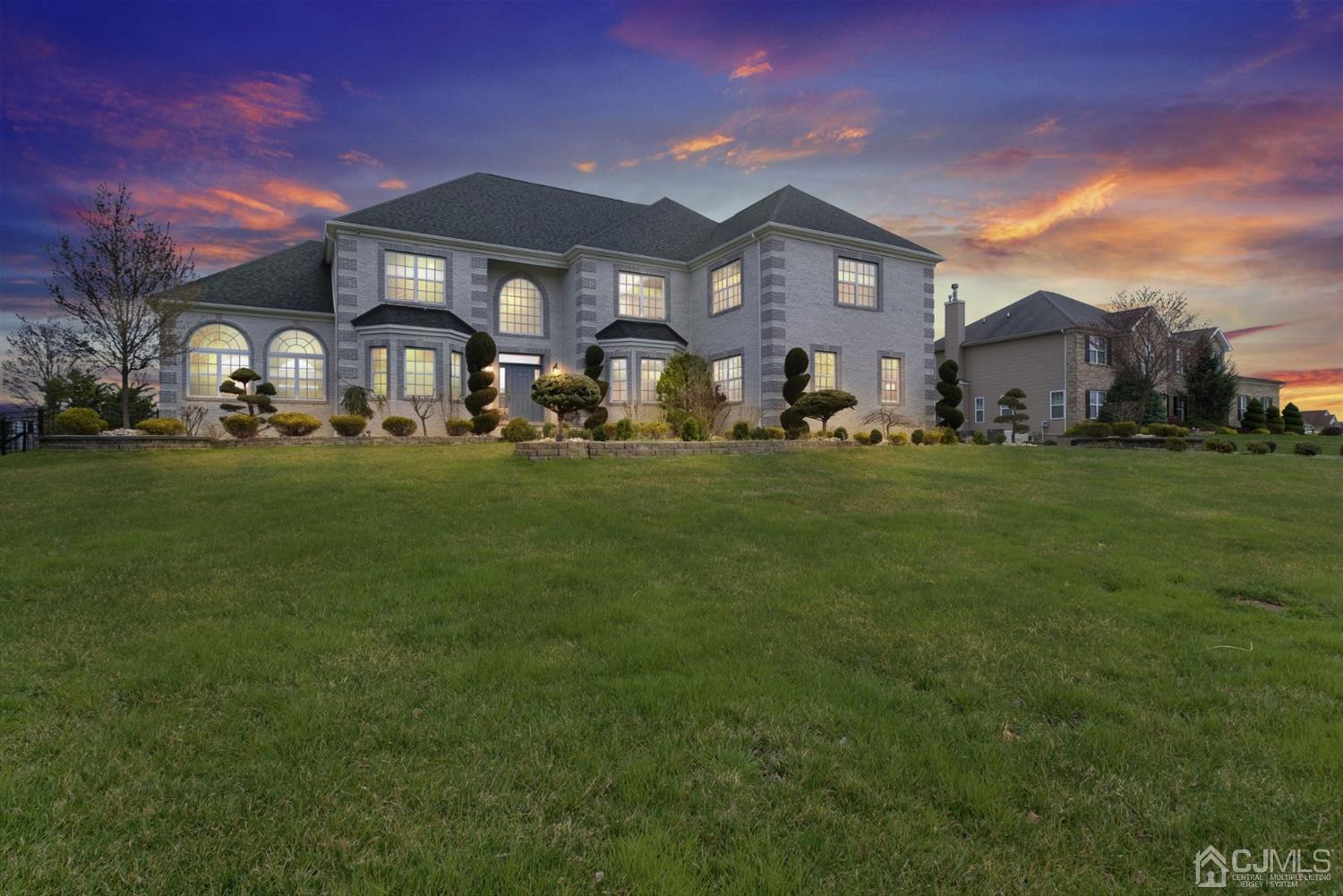 a front view of a residential houses with yard and green space