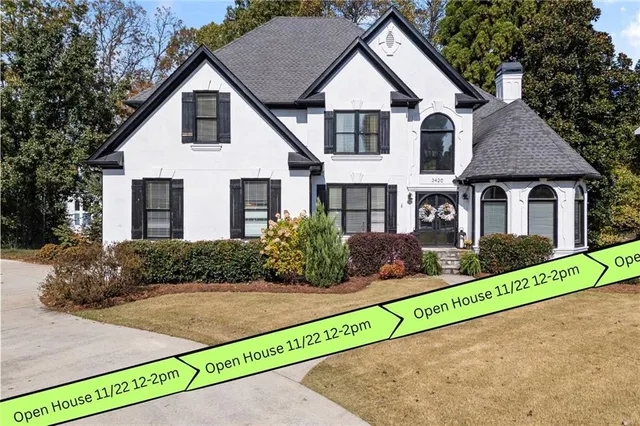 a front view of a house with a yard and potted plants