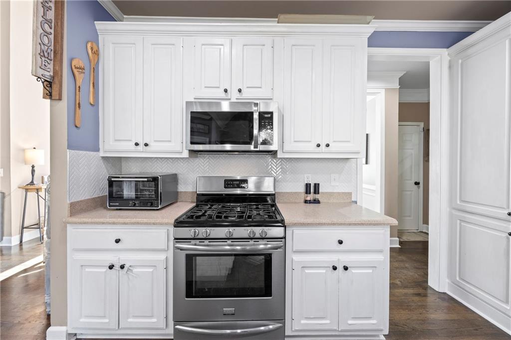 3420 Millwater Crossing Northeast Dacula, GA 30019 - Photo 15 of 54 a kitchen with cabinets stainless steel appliances and wooden floor