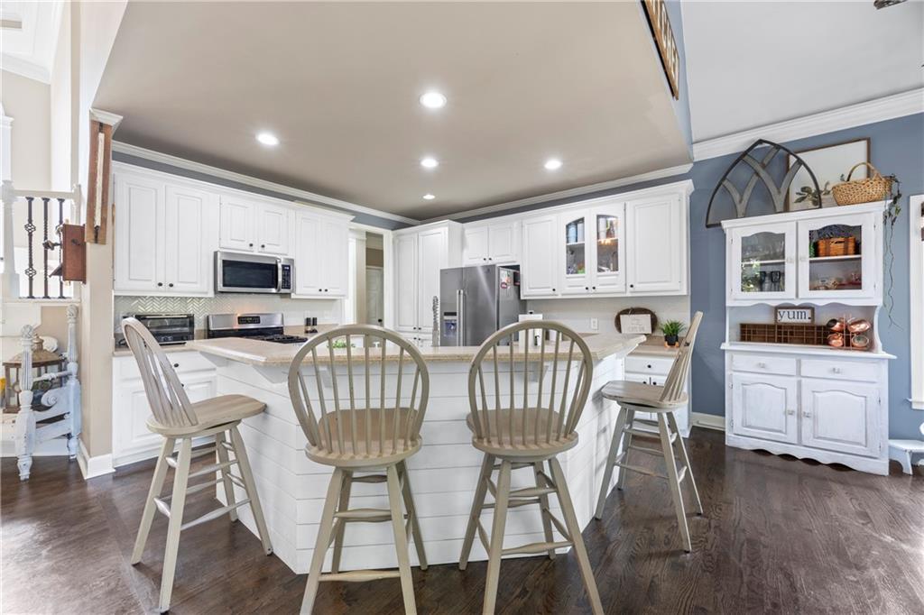 3420 Millwater Crossing Northeast Dacula, GA 30019 - Photo 16 of 54 a view of kitchen with stainless steel appliances granite countertop a dining table and chairs