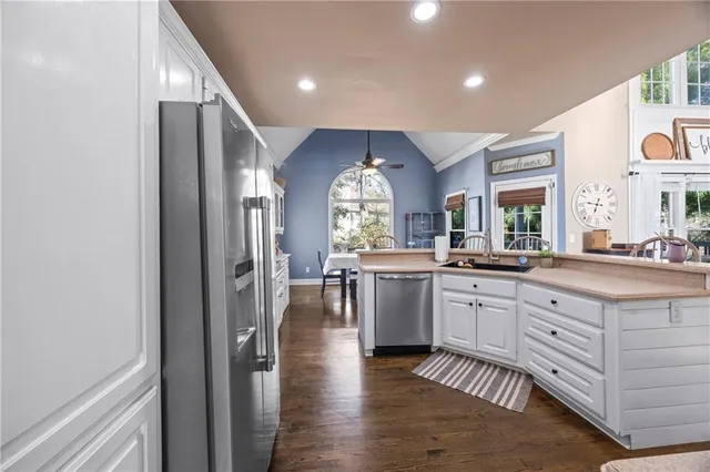 a kitchen with granite countertop lots of white cabinets and stainless steel appliances