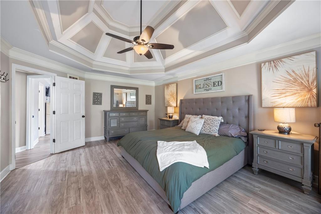 3420 Millwater Crossing Northeast Dacula, GA 30019 - Photo 23 of 54 a bedroom with a large bed and a chandelier