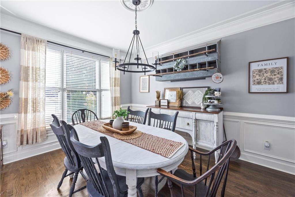 3420 Millwater Crossing Northeast Dacula, GA 30019 - Photo 7 of 54 a dining room with furniture a chandelier and wooden floor