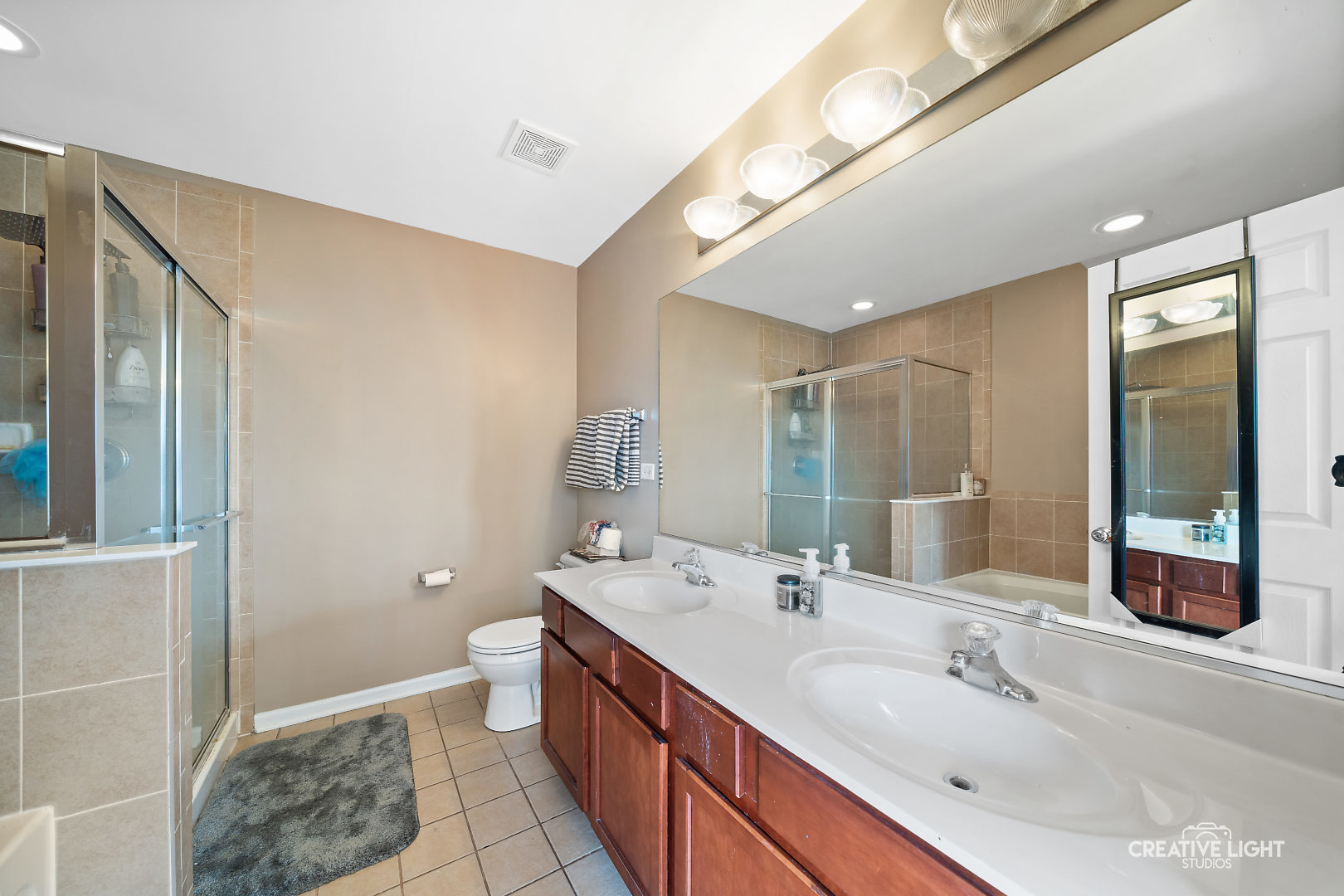 1987 West Cobblestone Road Romeoville, IL 60446 - Photo 14 of 20 a spacious bathroom with a double vanity sink a large mirror and a shower