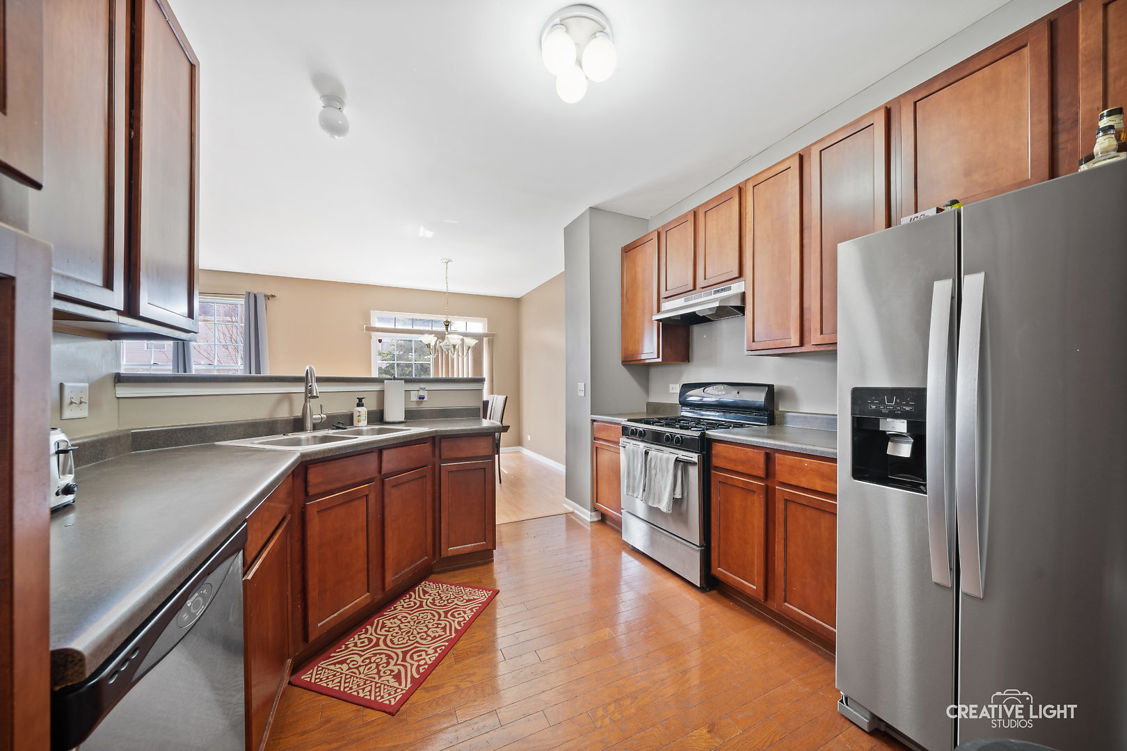 1987 West Cobblestone Road Romeoville, IL 60446 - Photo 9 of 20 a large kitchen with stainless steel appliances granite countertop a refrigerator a stove top oven a sink and dishwasher