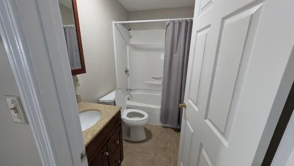 a bathroom with a granite countertop sink toilet and shower