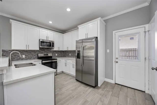 a kitchen with a refrigerator cabinets and wooden floor