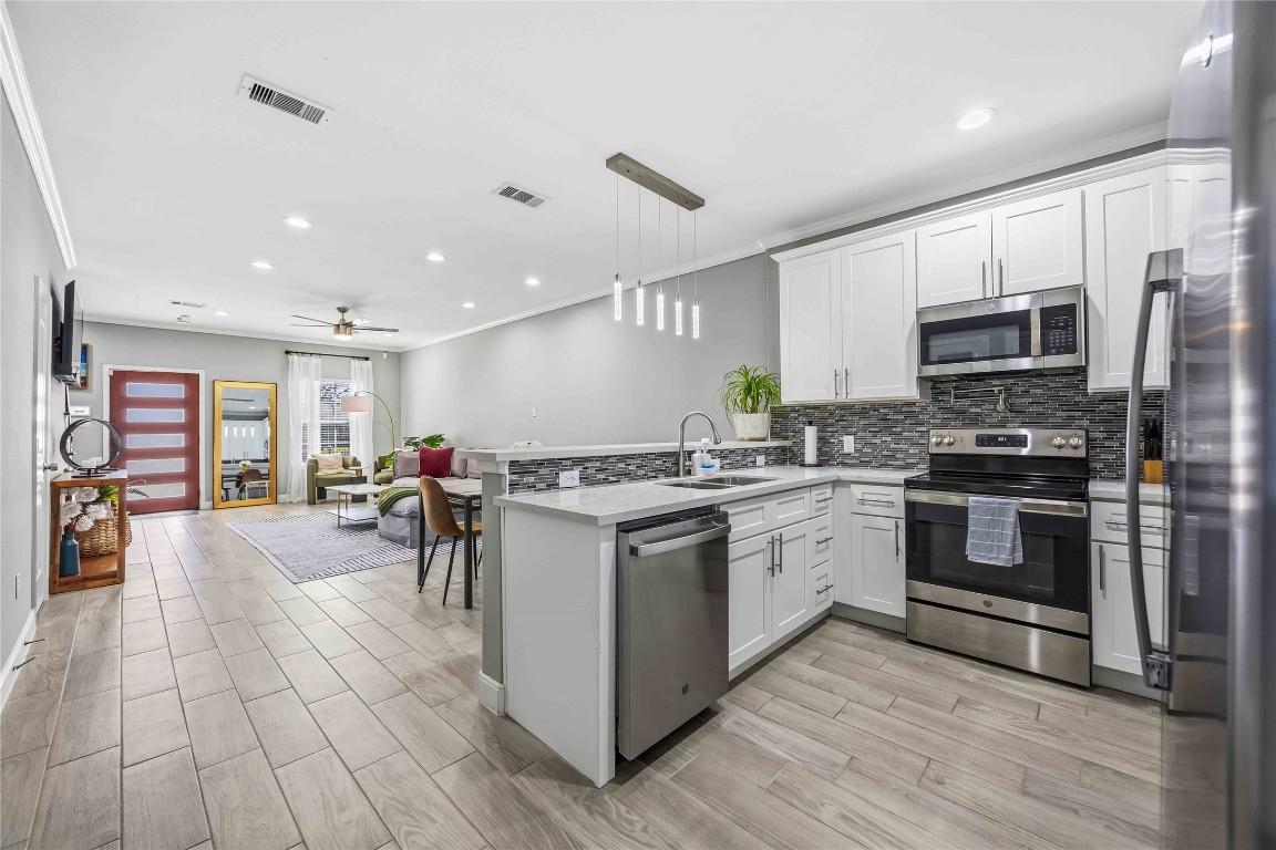 4903 Mallow Street, Unit A Houston, TX 77033 - Photo 5 of 10 a open kitchen with stainless steel appliances granite countertop a stove top oven a sink dishwasher a refrigerator and a dining table with wooden floor
