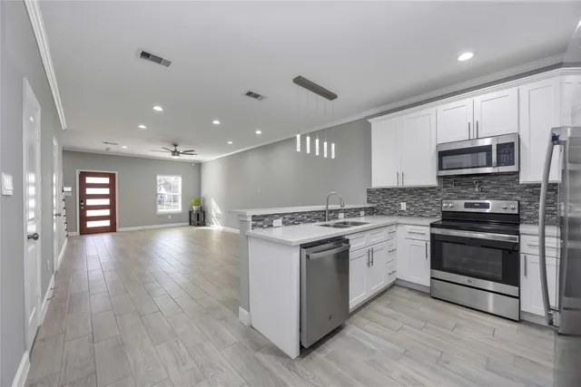 a kitchen with stainless steel appliances granite countertop a stove top oven and sink