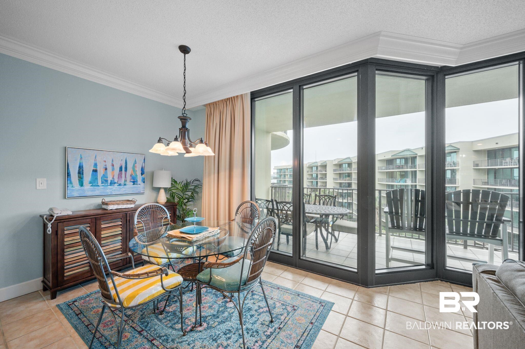 27580 Canal Road, Unit 1427 Orange Beach, AL 36561 - Photo 12 of 38 Dining room featuring crown molding, hanging lights, light tile patterned floors, a textured ceiling, and floor to ceiling windows