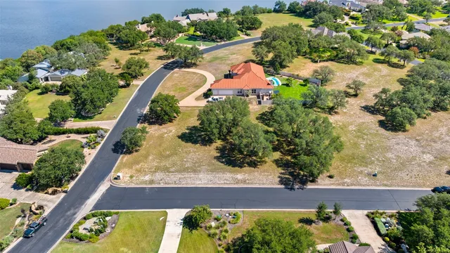 an aerial view of lake and residential houses with outdoor space