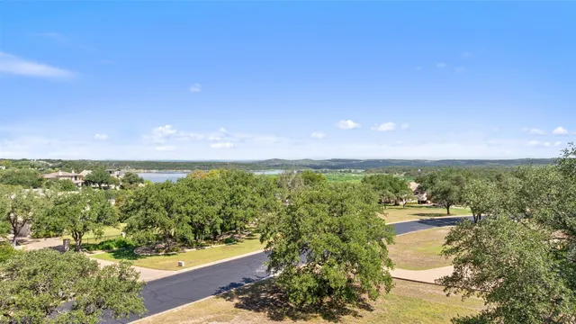 an aerial view of a houses with a yard and lake view