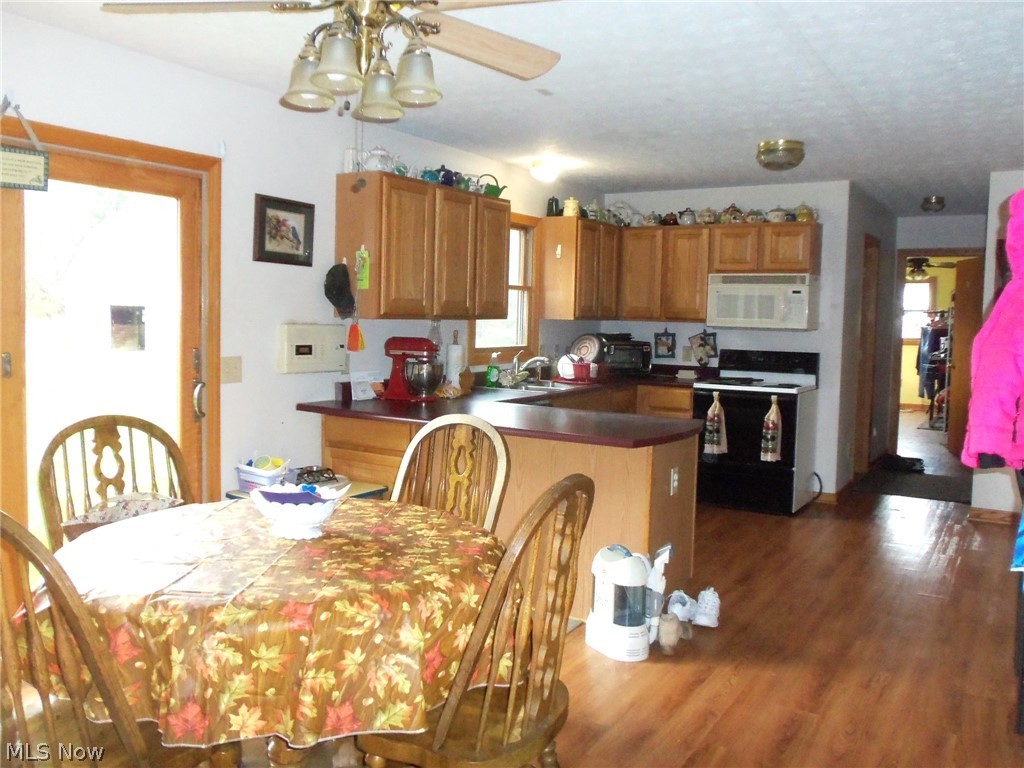 13760 Old State Road Middlefield, OH 44062 - Photo 2 of 18 County style kitchen with breakfast bar, dining area, large pantry and sliders to rear yard. Also has access to full bath, garage, large laundry/mudroom with double closet with access to rear yard.