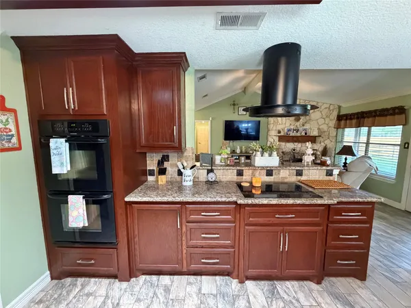 a kitchen with stainless steel appliances wooden cabinets a sink and a stove