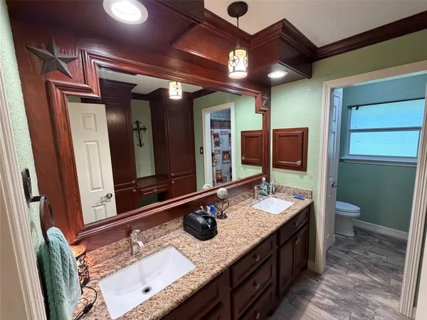 a bathroom with a granite countertop sink a mirror and a shower