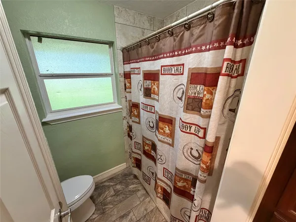 a spacious bedroom with a bed and a chandelier