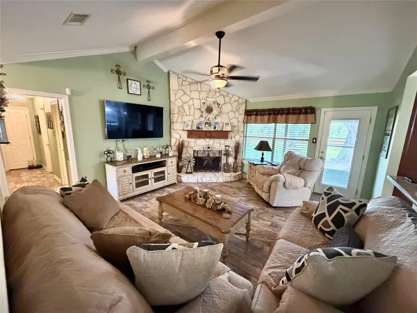 a living room with furniture a flat screen tv and a fireplace