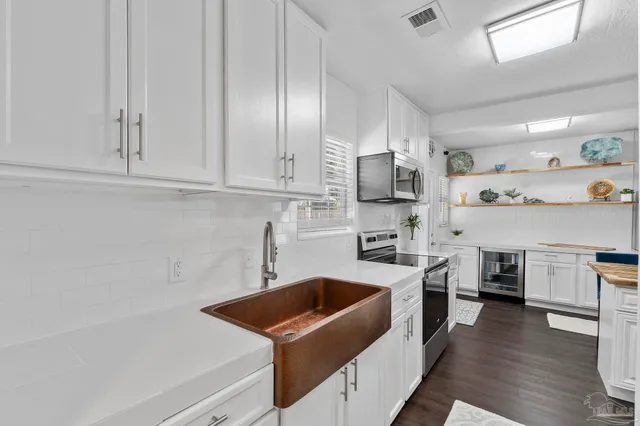 a kitchen with cabinets and wooden floor