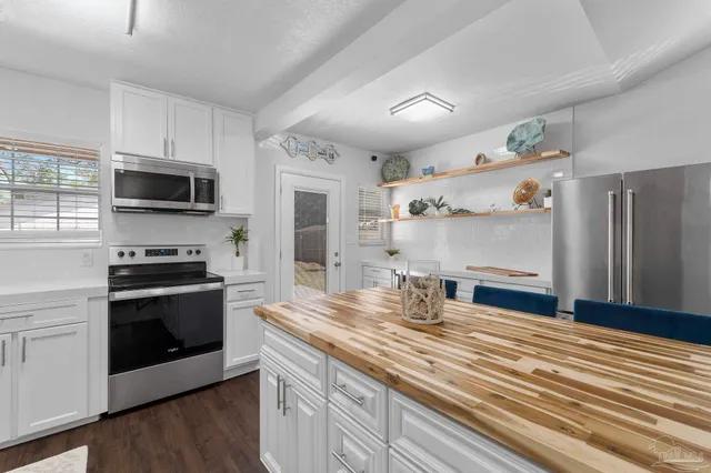 a kitchen with stainless steel appliances a stove microwave and sink