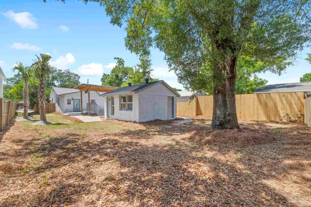 a view of a house with backyard and tree