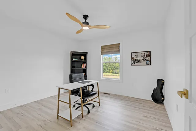 a view of a workspace with furniture and wooden floor