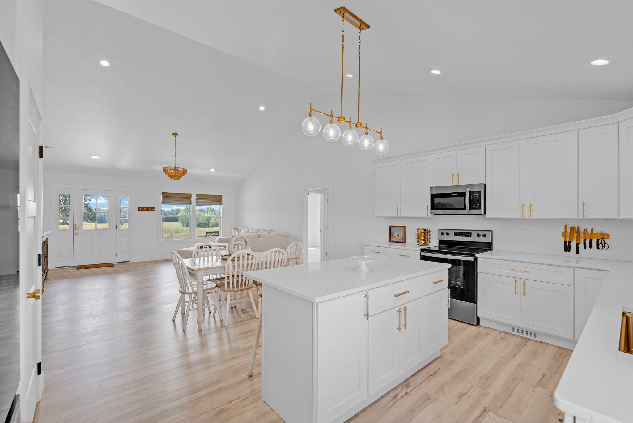 4733 Window Cliff Road Baxter, TN 38544 - Photo 2 of 25 a kitchen with stainless steel appliances a microwave a stove a sink dishwasher a refrigerator and white cabinets with wooden floor